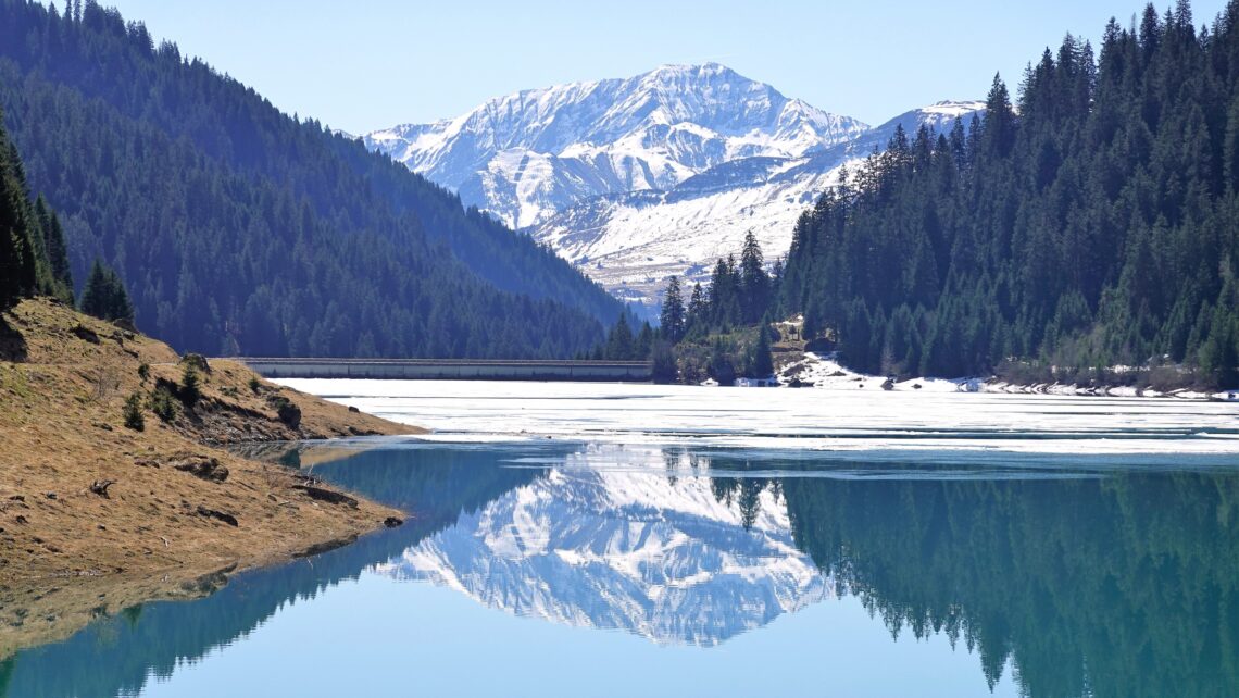 Mountain lake surrounded by mountains reflecting calm water, symbolizing healing and personal transformation