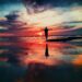 Person standing in shallow ocean water at sunrise, reflecting on healing, trust, and new beginnings.