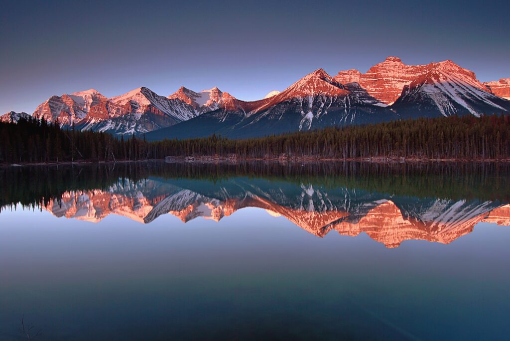 Calm mountain landscape reflected in a lake representing reflection, growth, and the power of the mind.