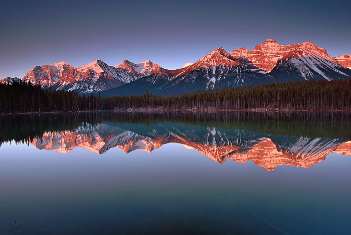 Calm mountain landscape reflected in a lake representing reflection, growth, and the power of the mind.