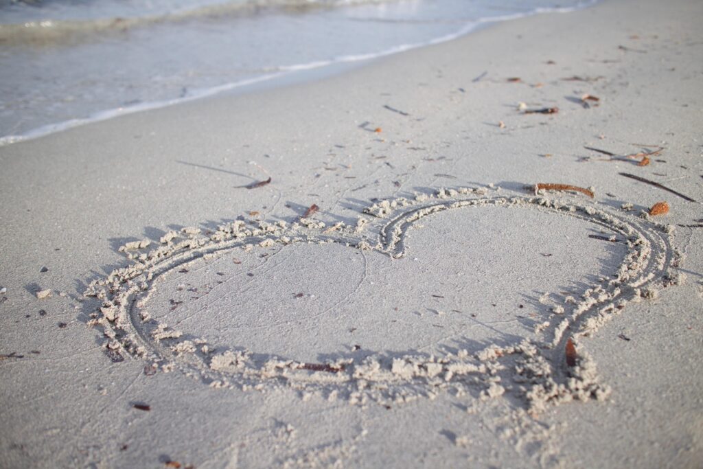 Heart drawn in the sand on a peaceful beach, symbolizing love, emotional healing, compassion, and creating emotionally safe homes.