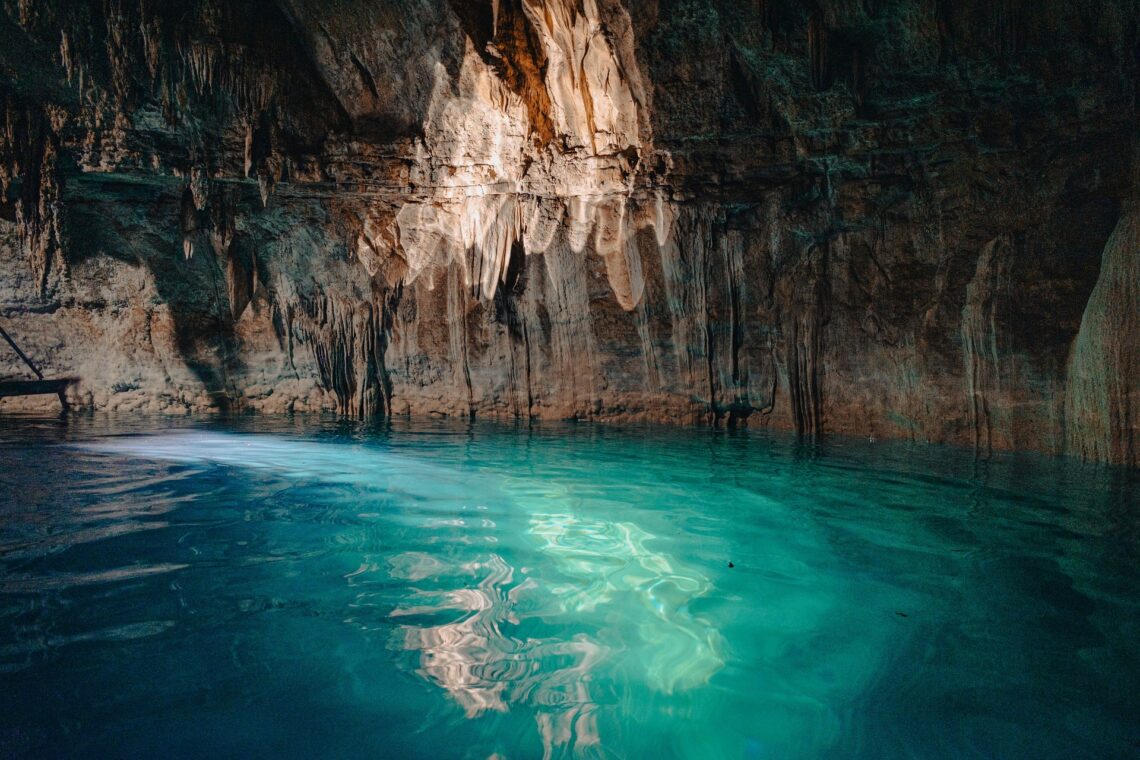 Turquoise water inside a rocky cave illuminated by natural light