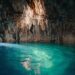 Turquoise water inside a rocky cave illuminated by natural light